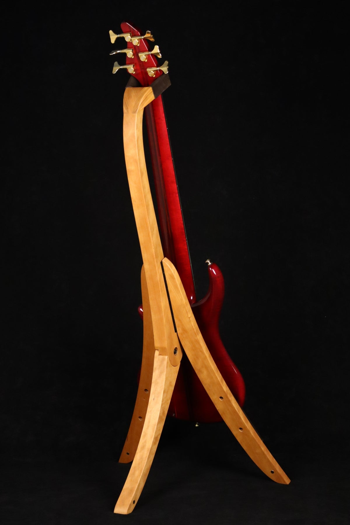 Folding cherry wood electric bass guitar floor stand full rear image with Pedulla 6 string fretless bass