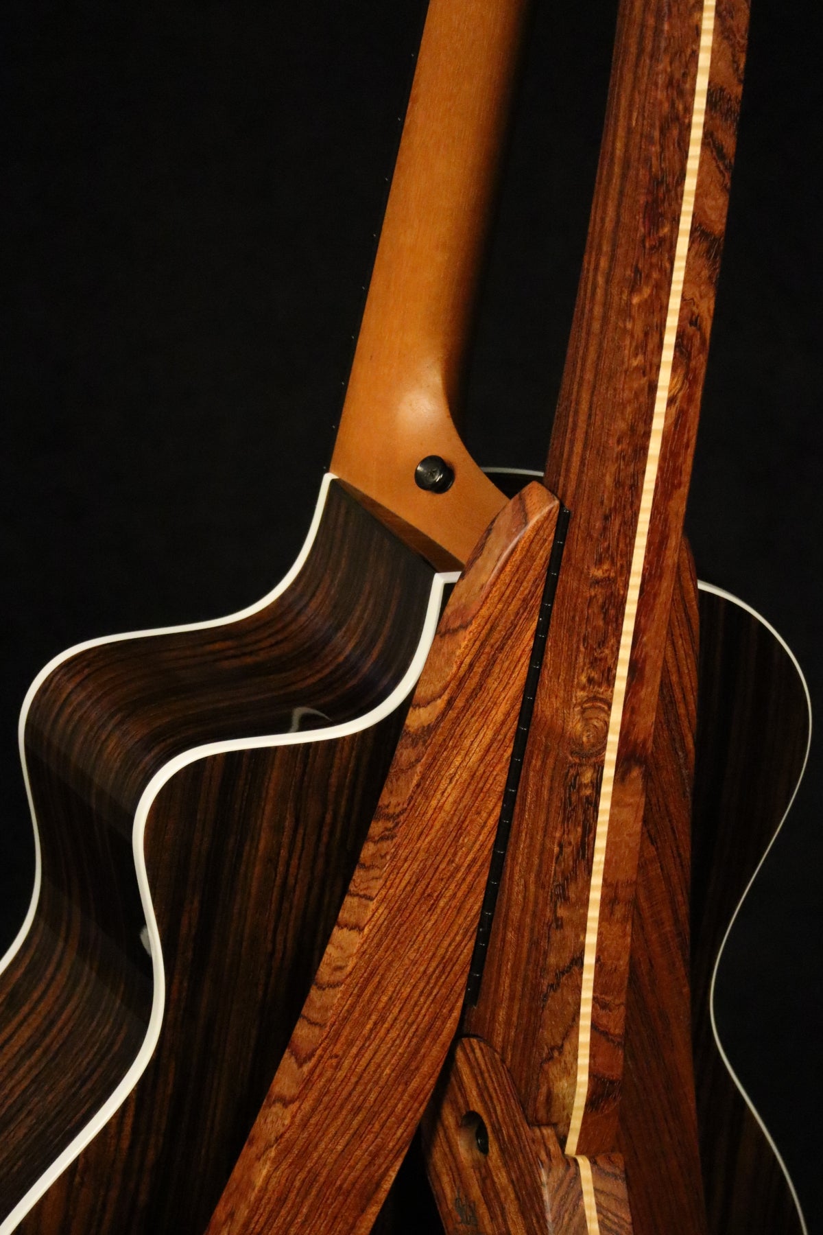 Folding bubinga rosewood and curly maple wood guitar floor stand closeup rear image with Taylor guitar