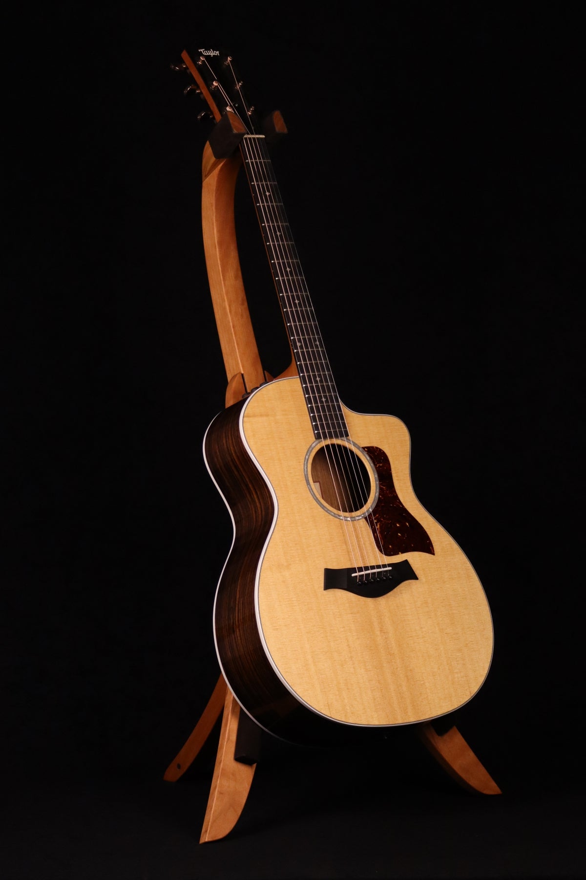 Folding cherry wood guitar floor stand full front image with Taylor guitar