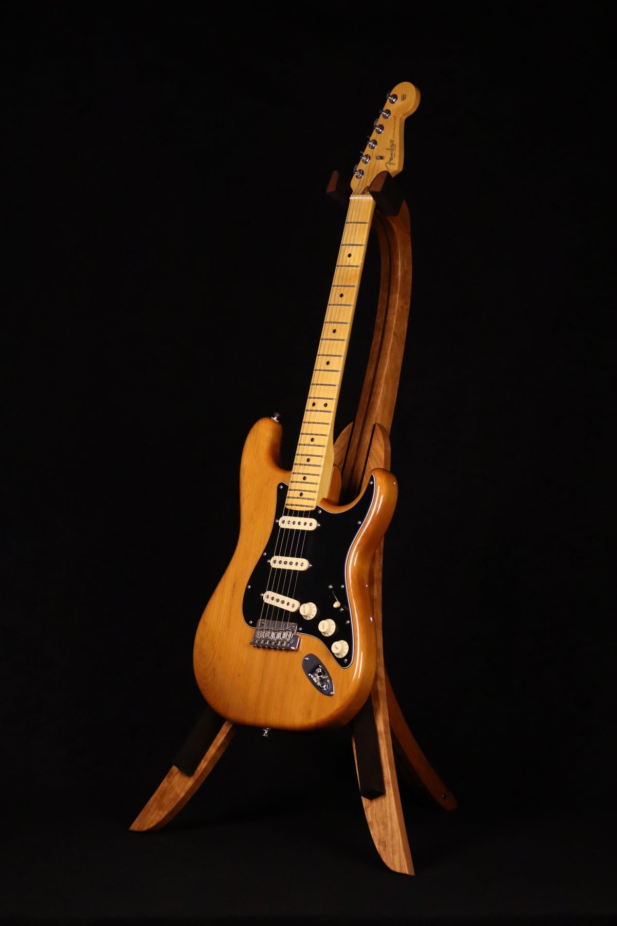 Folding cherry and walnut wood guitar floor stand full front image with Fender guitar
