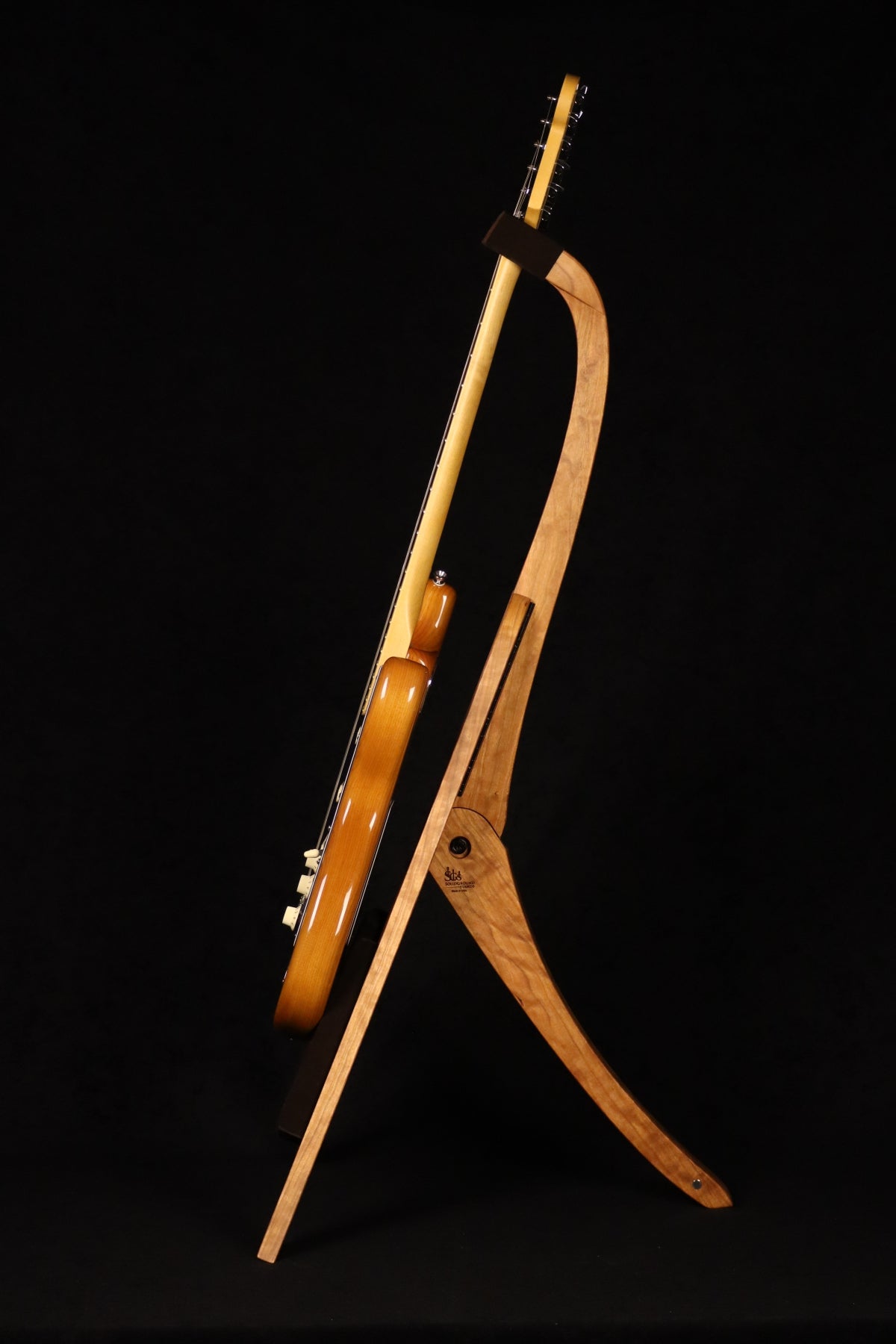 Folding cherry and walnut wood guitar floor stand full side image with Fender guitar