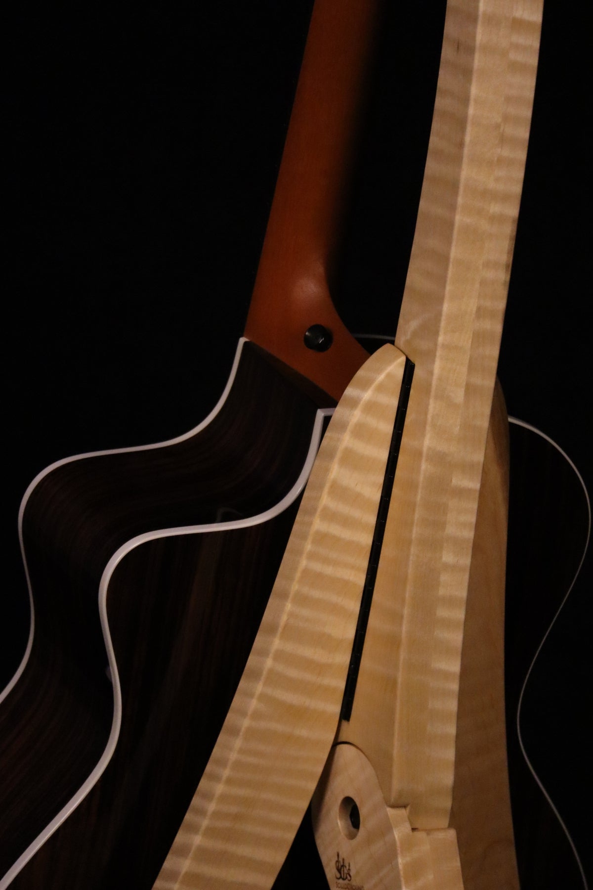 Folding curly maple wood guitar floor stand closeup rear image with Taylor guitar