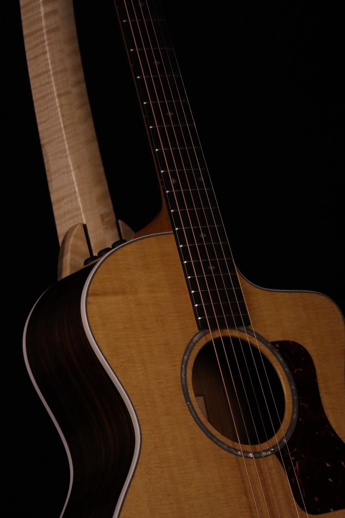 Folding curly maple wood guitar floor stand closeup front image with Taylor guitar