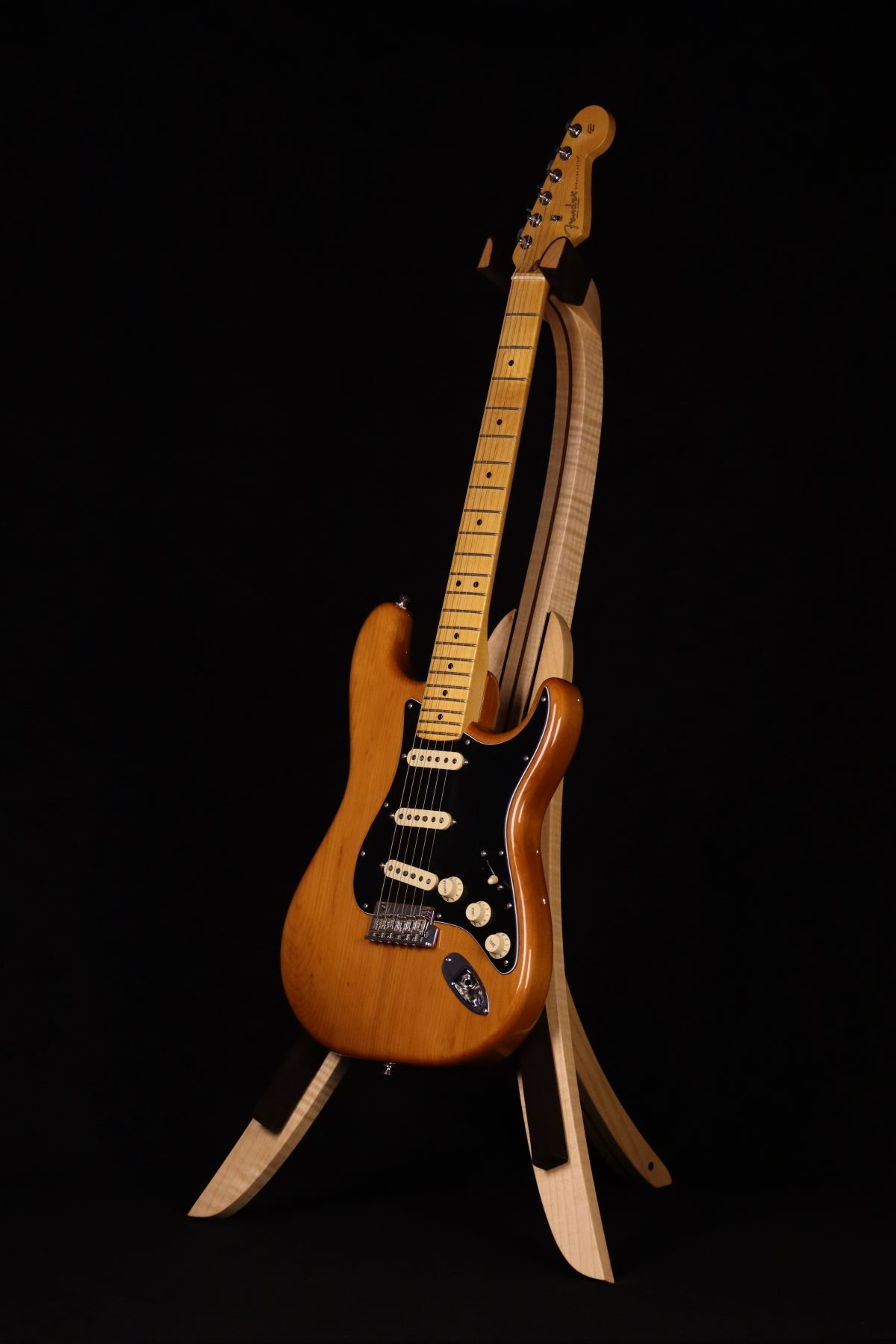 Folding curly maple and walnut wood guitar floor stand full front image with Fender guitar