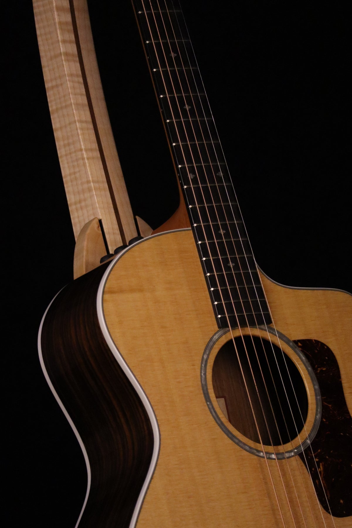 Folding curly maple and walnut wood guitar floor stand closeup front image with Taylor guitar