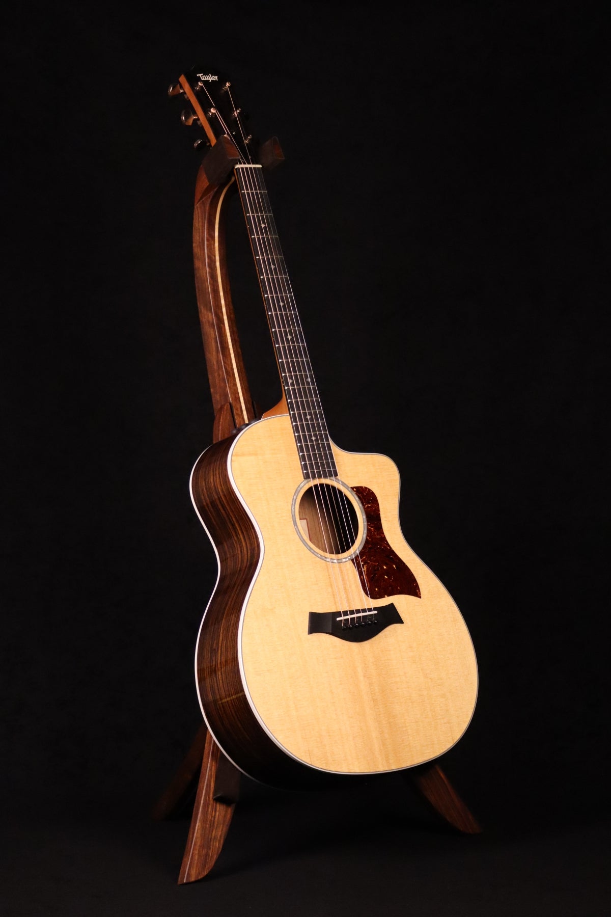Folding chechen Caribbean rosewood and curly maple wood guitar floor stand full front image with Taylor guitar