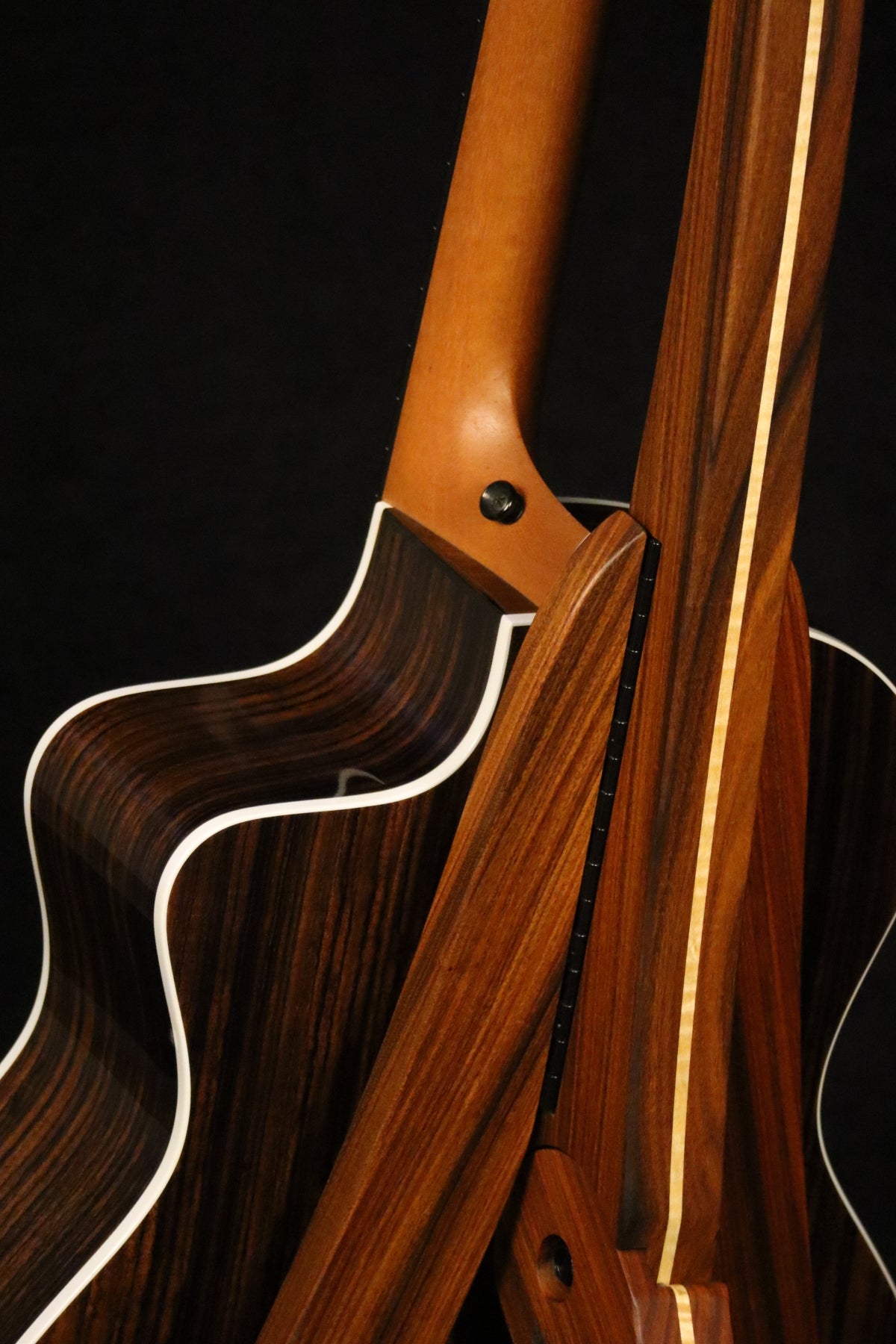 Folding morado Bolivian rosewood pau fero and curly maple wood guitar floor stand closeup rear image with Taylor guitar