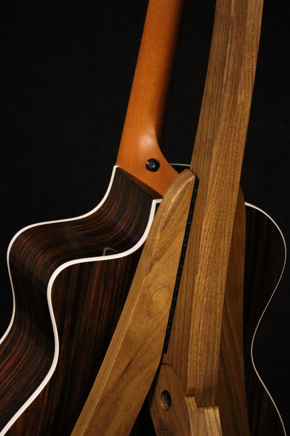 Folding walnut wood guitar floor stand closeup rear image with Taylor guitar