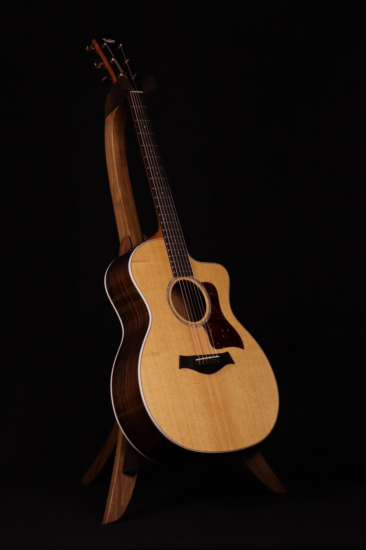 Folding walnut wood guitar floor stand full front image with Taylor guitar