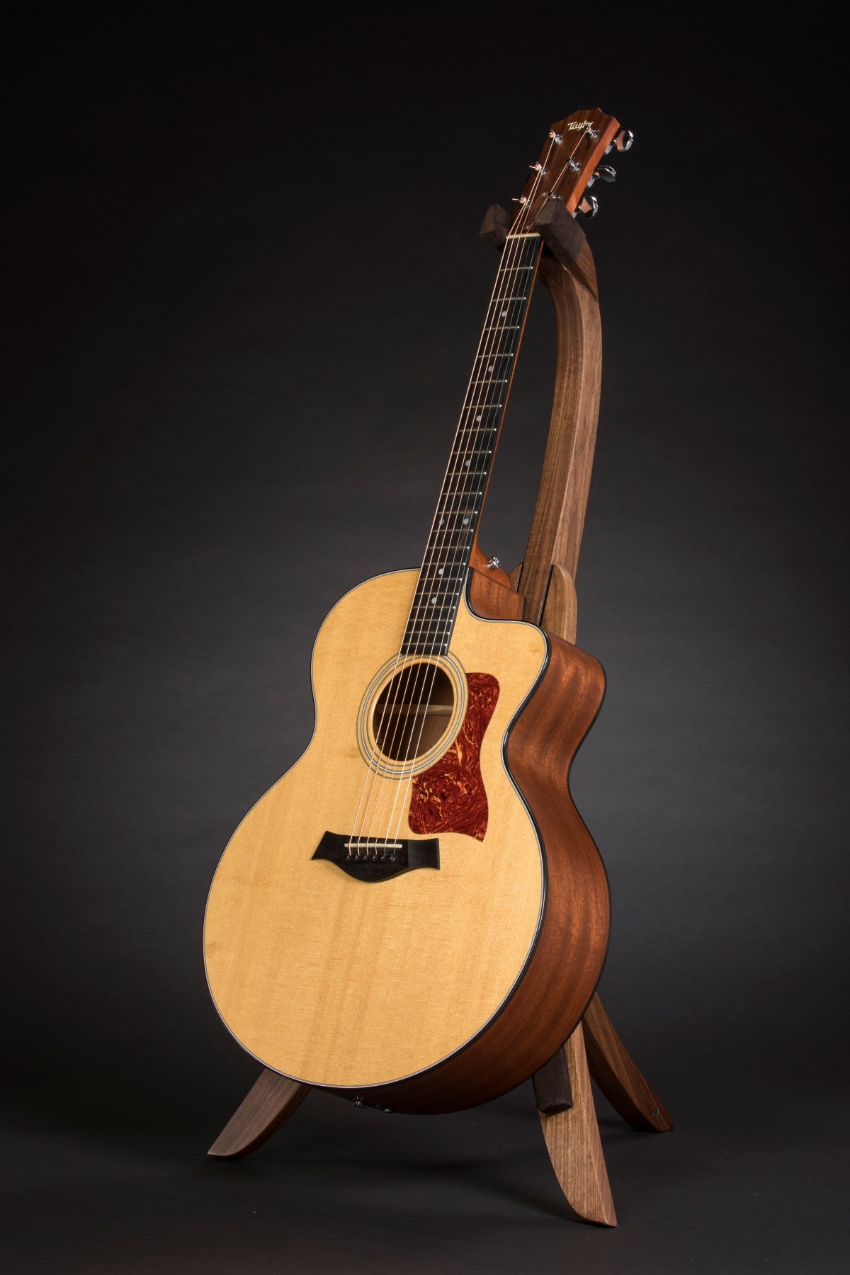 Folding walnut wood guitar floor stand full front image with Taylor guitar