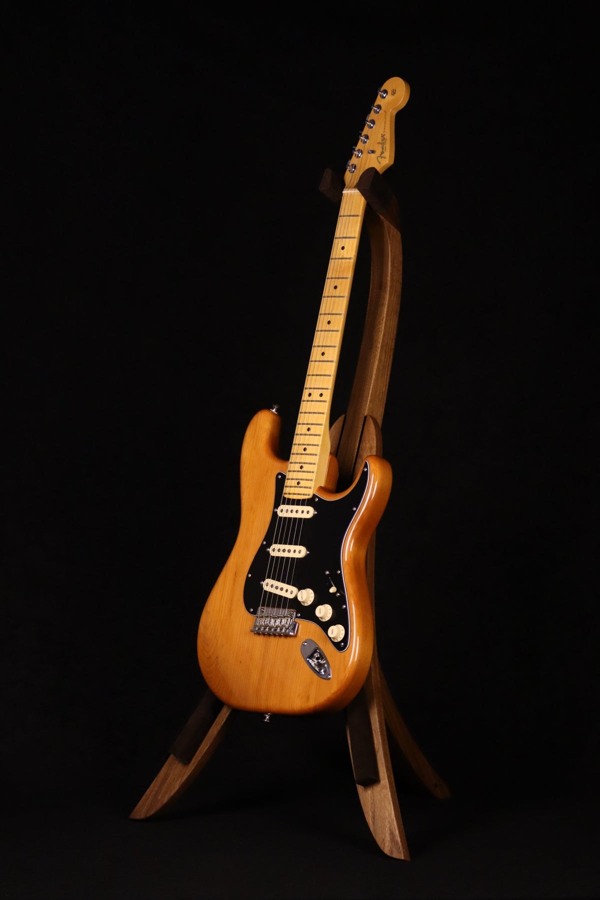 Folding walnut wood guitar floor stand full front image with Fender guitar