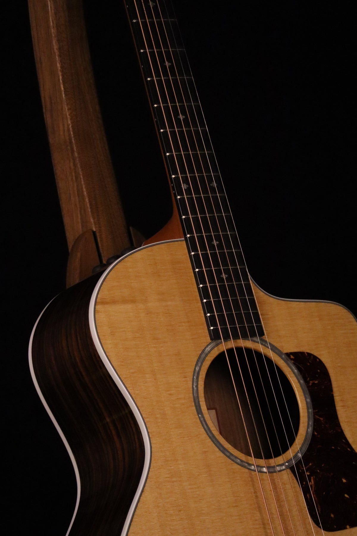Folding walnut wood guitar floor stand closeup front image with Taylor guitar