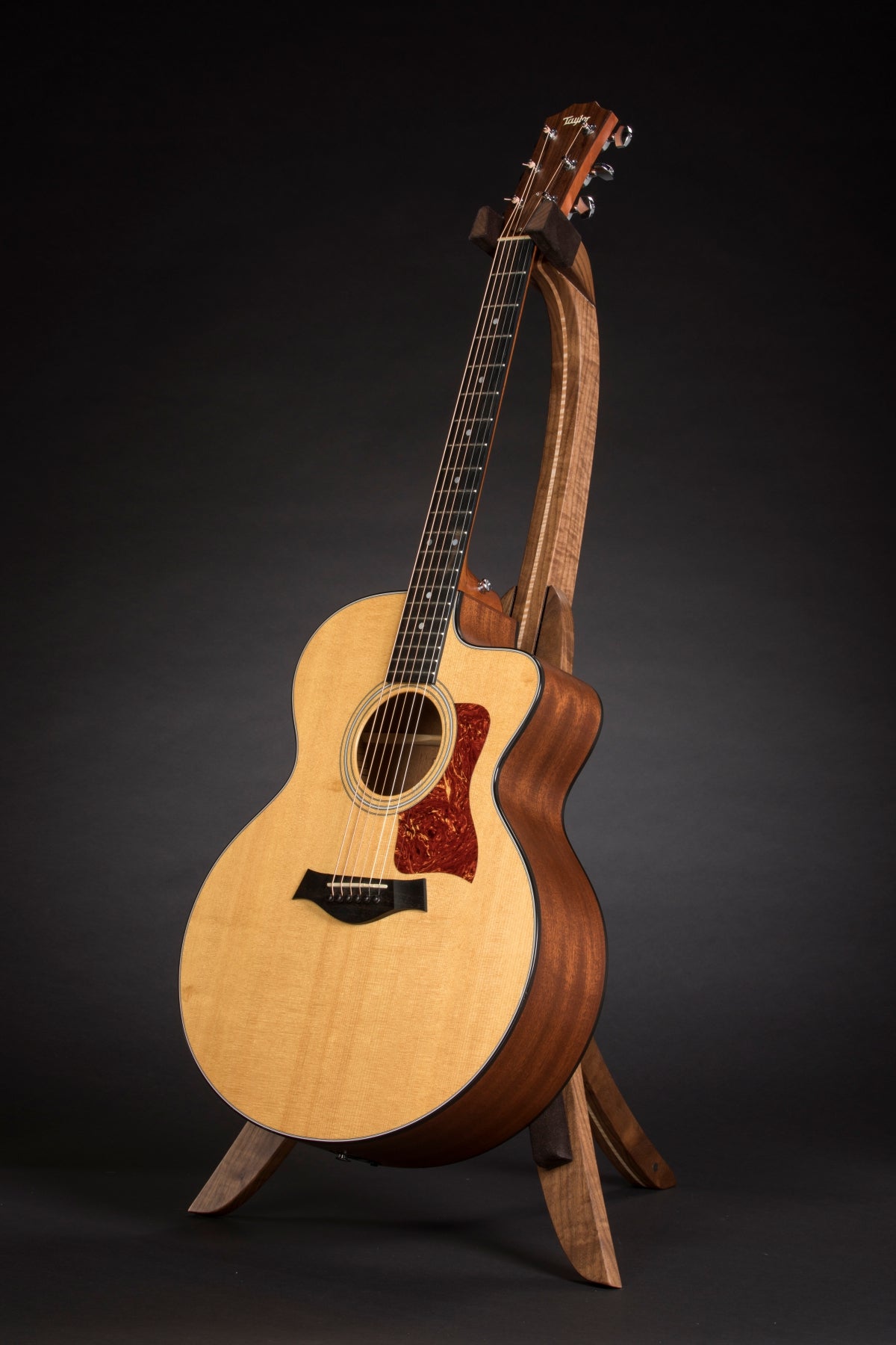 Folding walnut and curly maple wood guitar floor stand full front image with Taylor guitar
