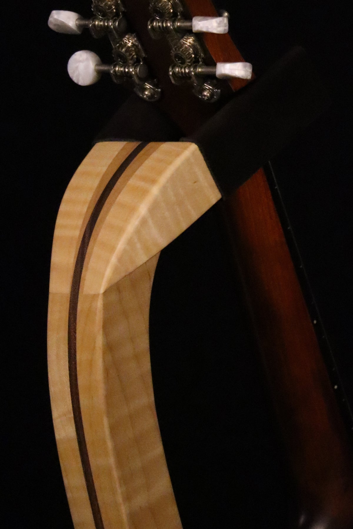 Folding curly maple and walnut wood mandolin floor stand yoke detail image with Eastman mandolin