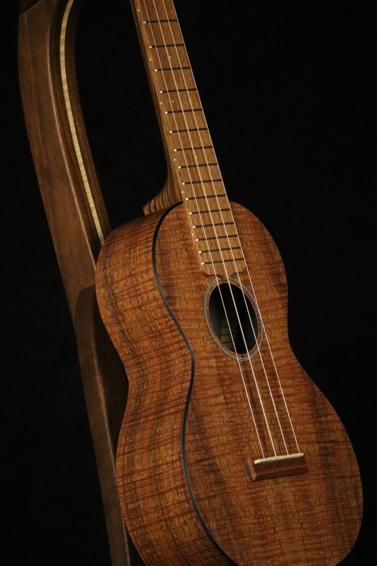 Folding walnut and curly maple wood ukulele floor stand closeup front image with Martin ukulele