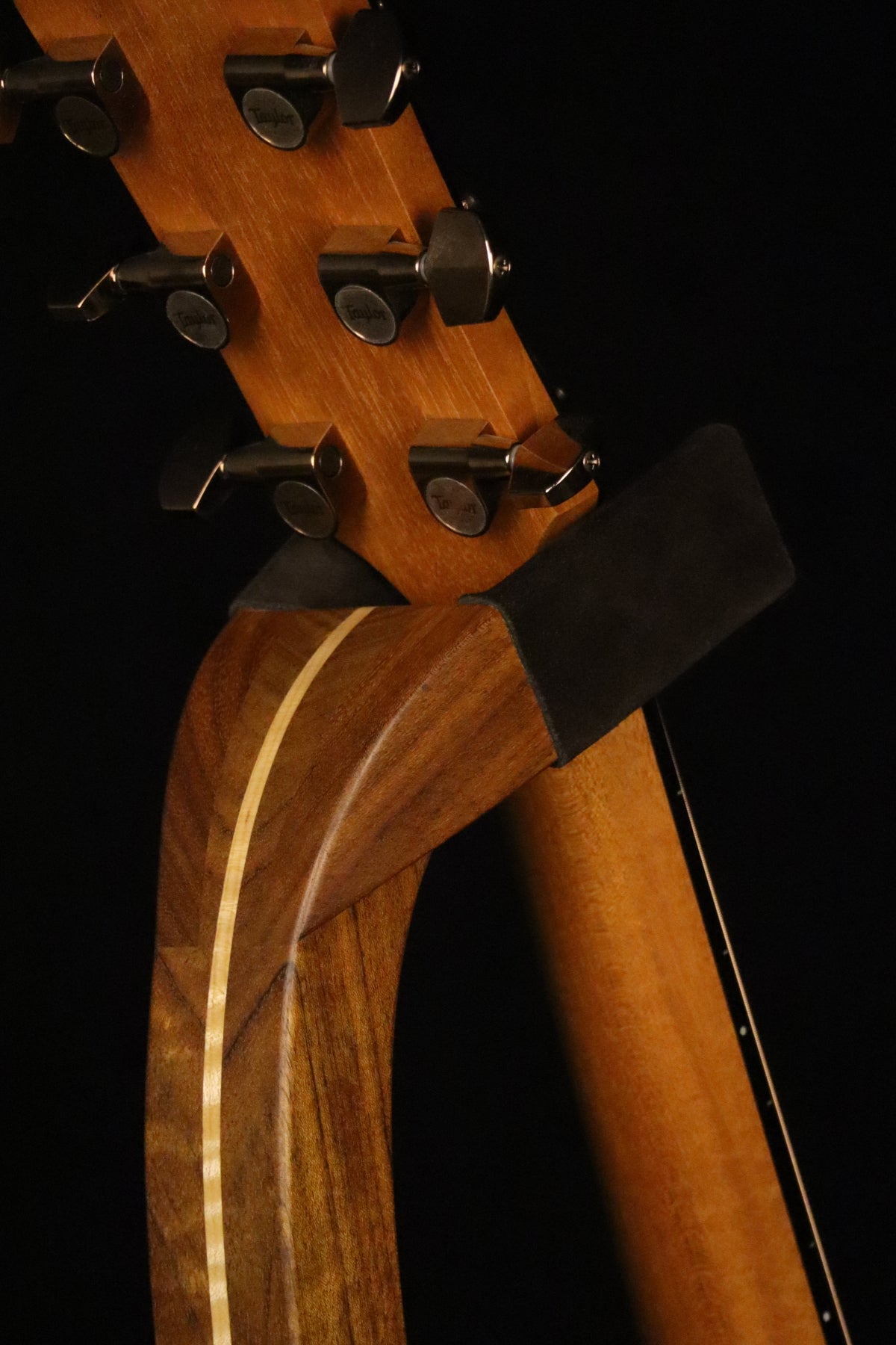 Folding sheuda ovangkol and curly maple wood guitar stand yoke detail image with Taylor guitar