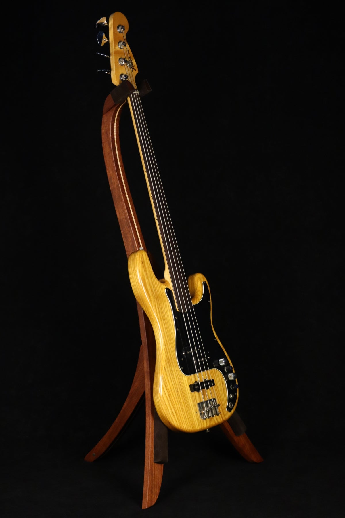 Folding bubinga rosewood and curly maple wood electric bass guitar floor stand full front image with Fender 4 string fretless bass