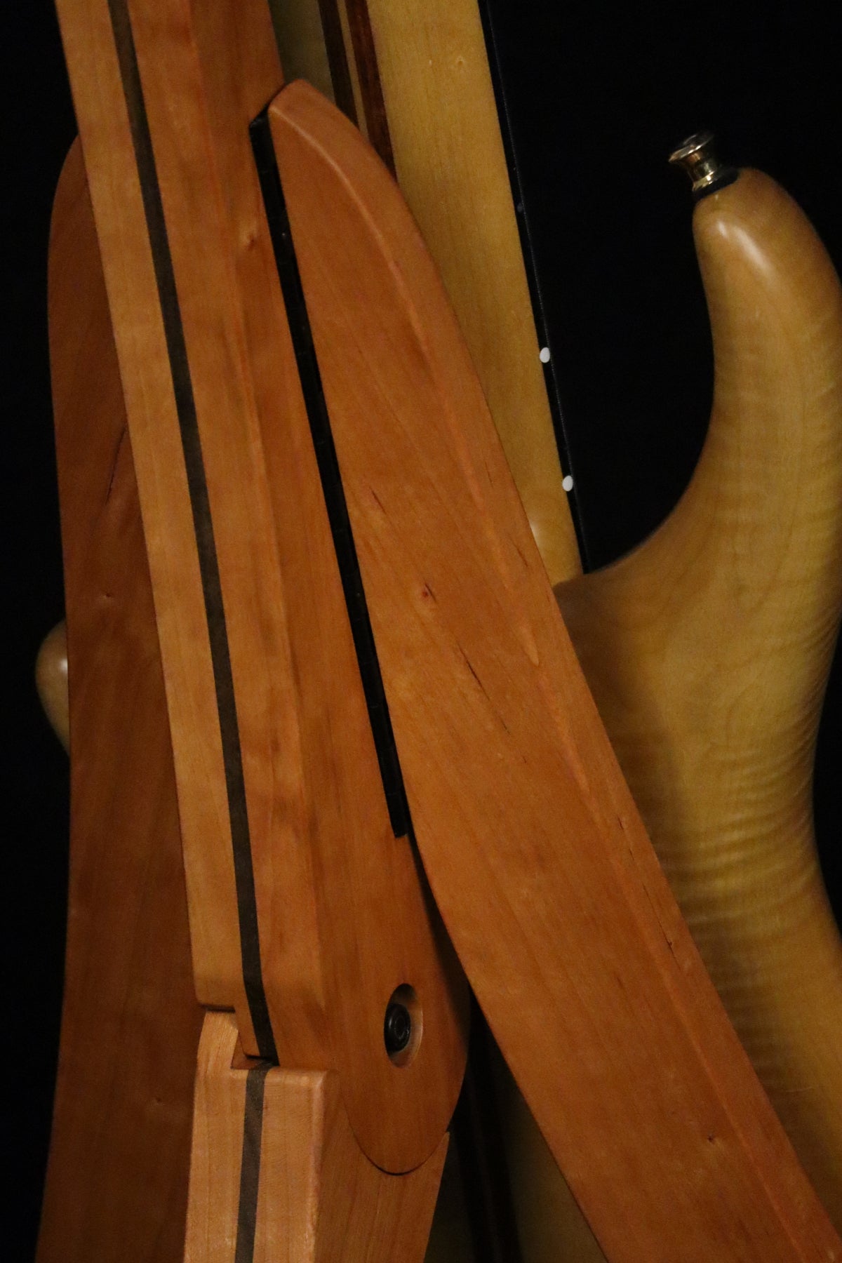 Folding cherry and walnut wood electric bass guitar floor stand closeup rear image