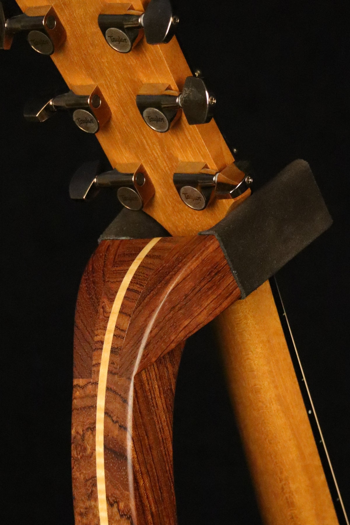 Folding bubinga rosewood and curly maple wood guitar floor stand yoke detail image with Taylor guitar