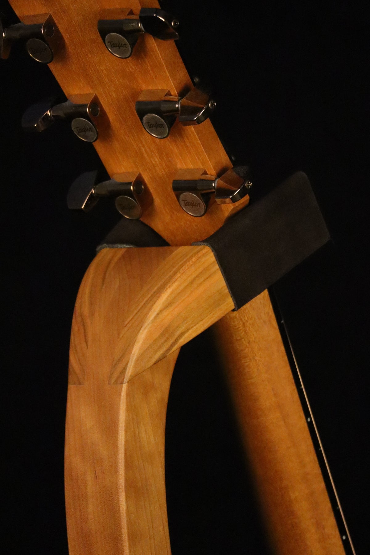 Folding cherry wood guitar floor stand yoke detail image with Taylor guitar