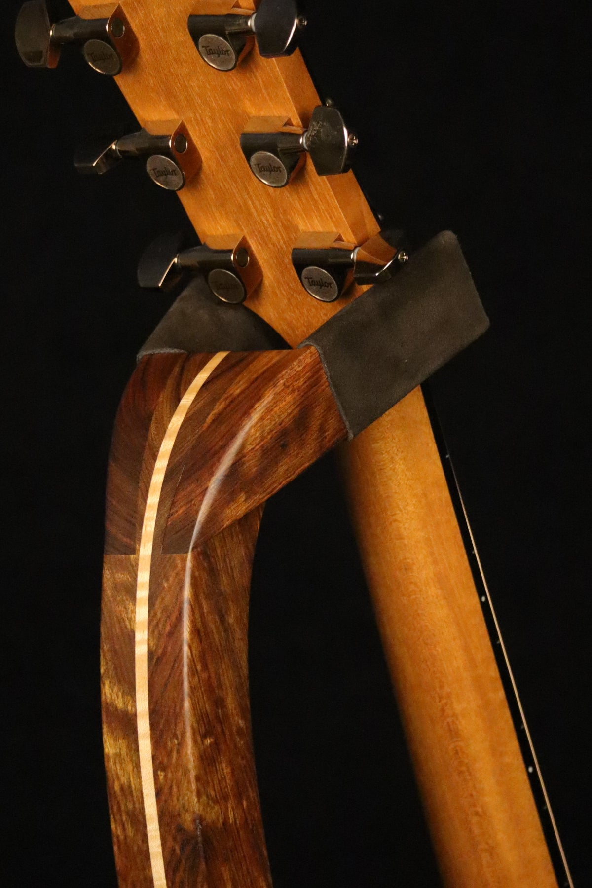 Folding chechen Caribbean rosewood and curly maple wood guitar floor stand yoke detail image with Taylor guitar