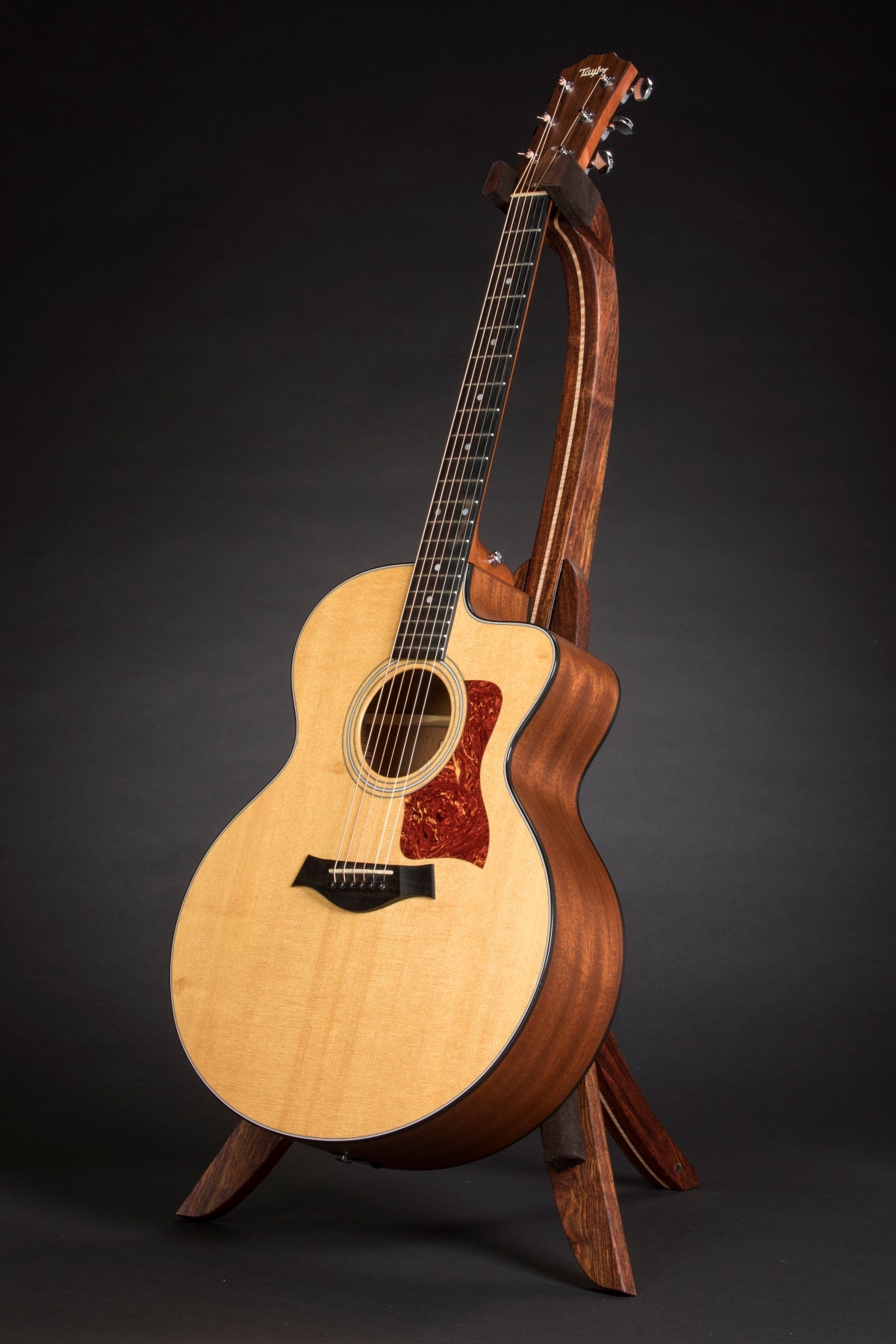 Folding chechen Caribbean rosewood and curly maple wood guitar floor stand full front image with Taylor guitar