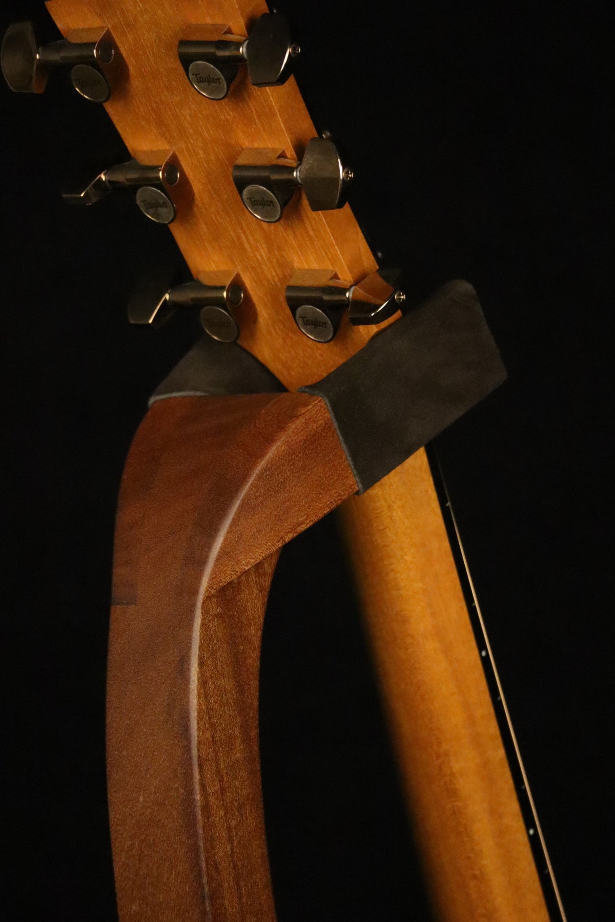 Folding sapele mahogany wood guitar floor stand yoke detail image with Taylor guitar