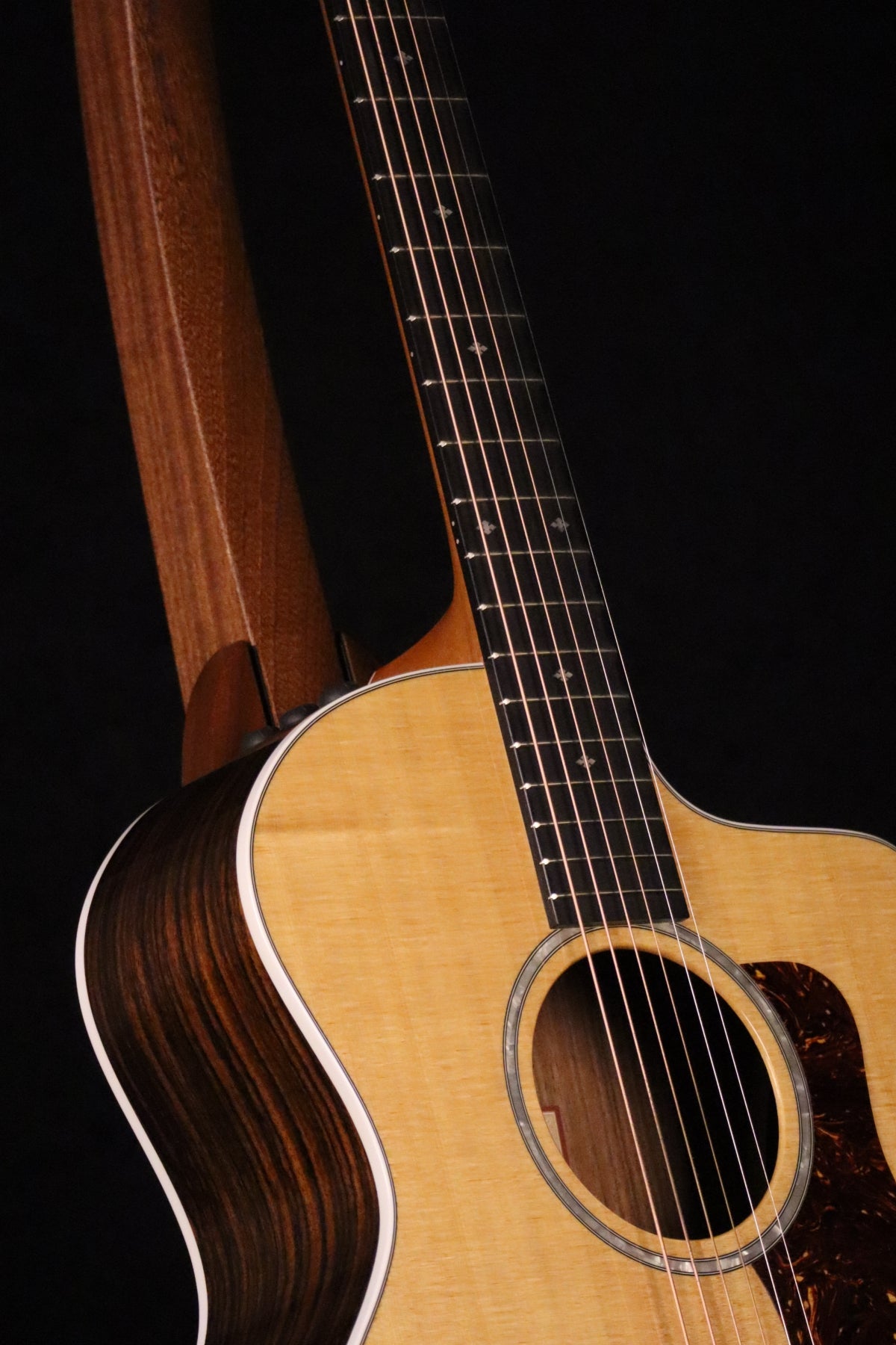 Folding sapele mahogany wood guitar floor stand closeup front image with Taylor guitar