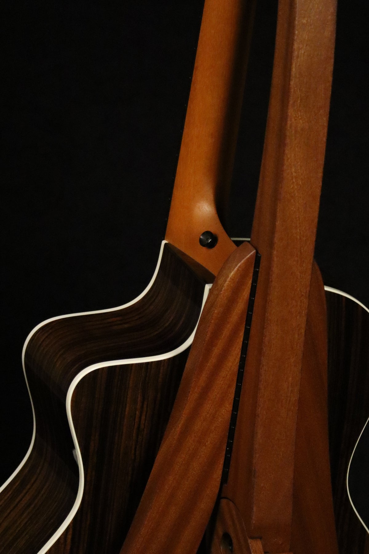 Folding sapele mahogany wood guitar floor stand closeup rear image with Taylor guitar