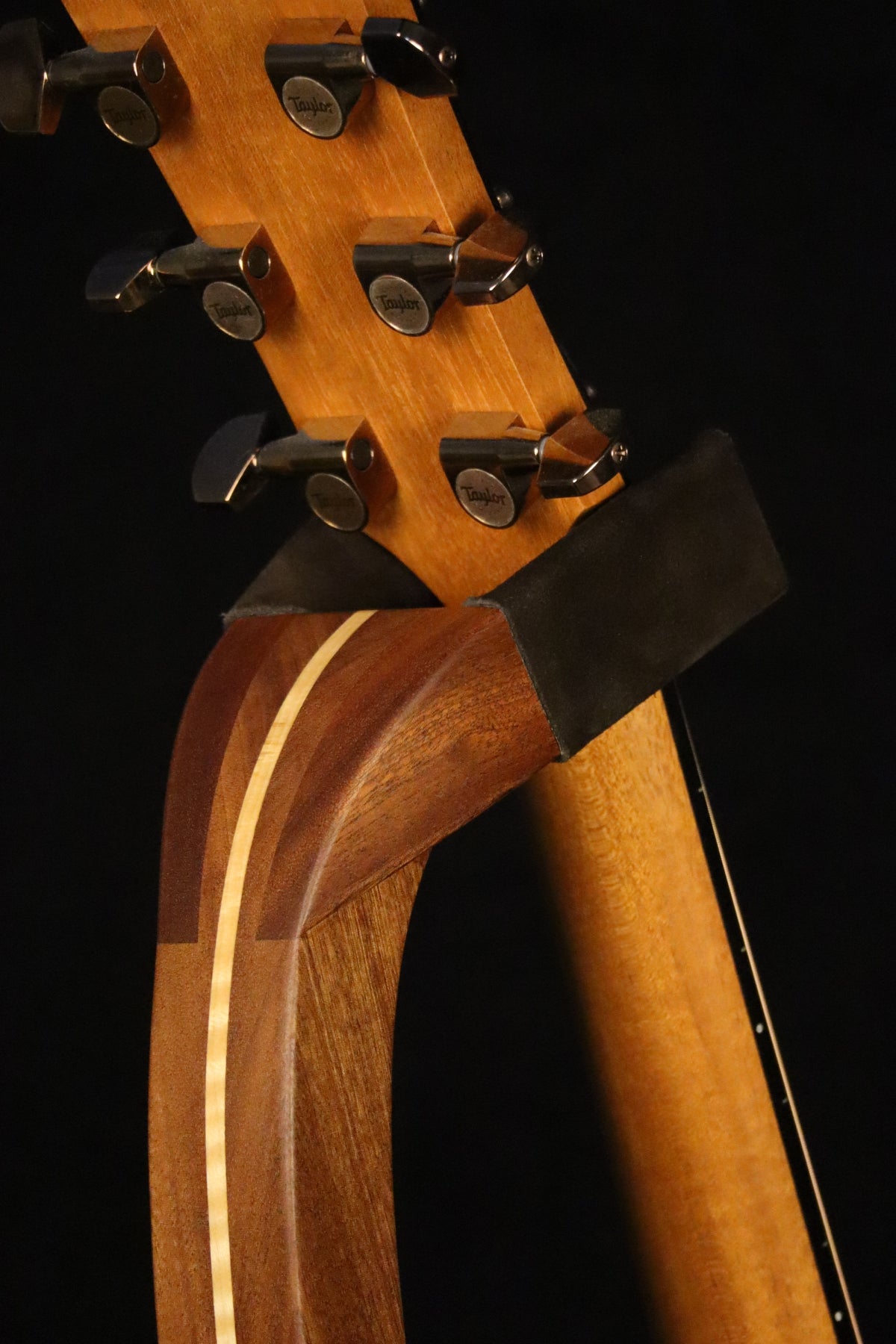 Folding sapele mahogany and curly maple wood guitar floor stand yoke detail image with Taylor guitar