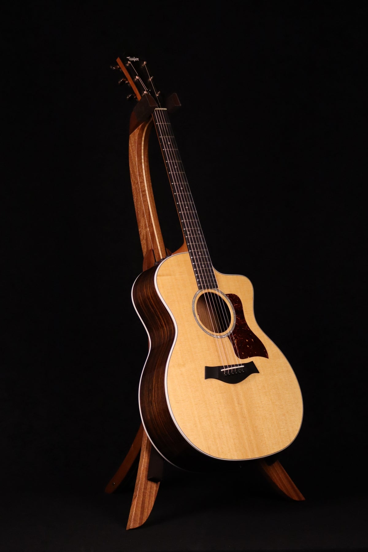 Folding sapele mahogany and curly maple wood guitar floor stand full front image with Taylor guitar