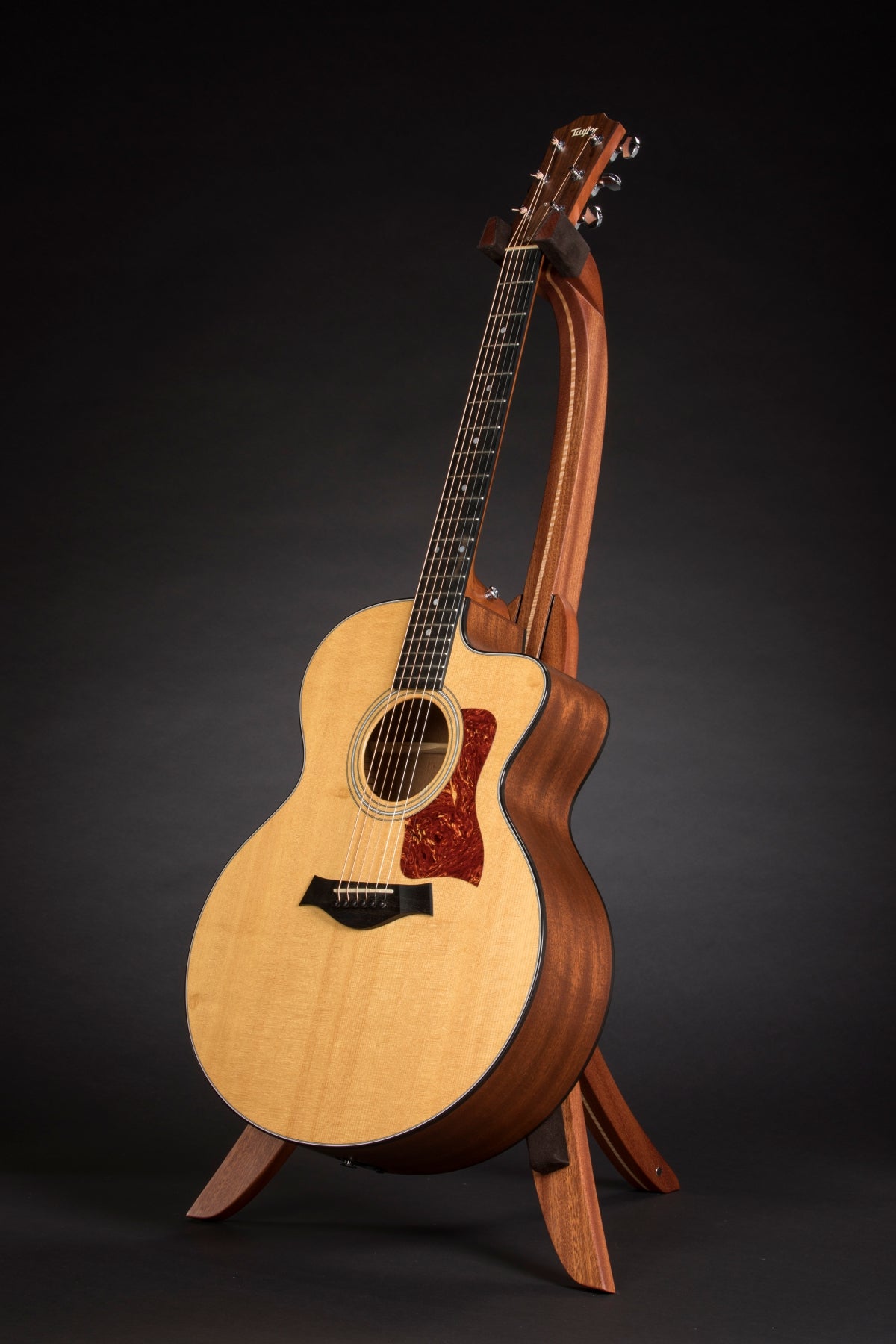 Folding sapele mahogany and curly maple wood guitar floor stand full front image with Taylor guitar