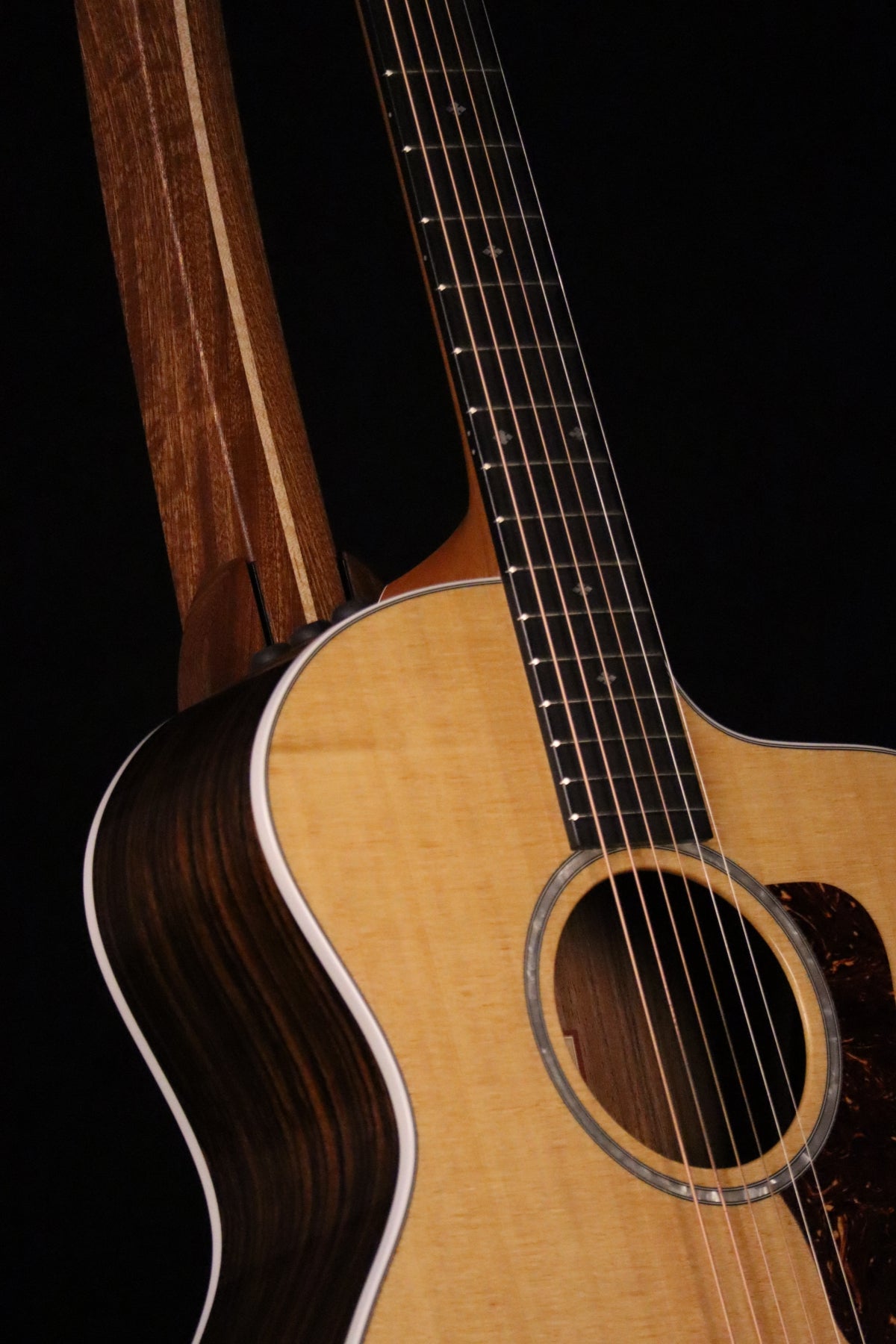 Folding sapele mahogany and curly maple wood guitar floor stand closeup front image with Taylor guitar