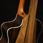 Folding walnut wood guitar floor stand closeup rear image with Taylor guitar