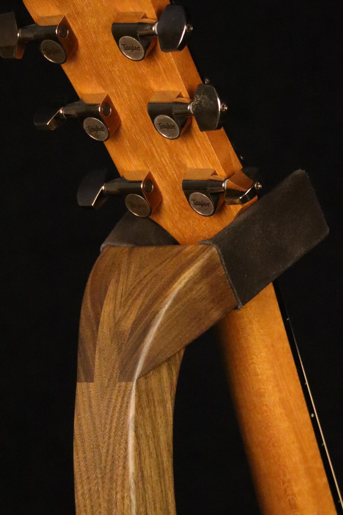 Folding walnut wood guitar floor stand yoke detail image with Taylor guitar