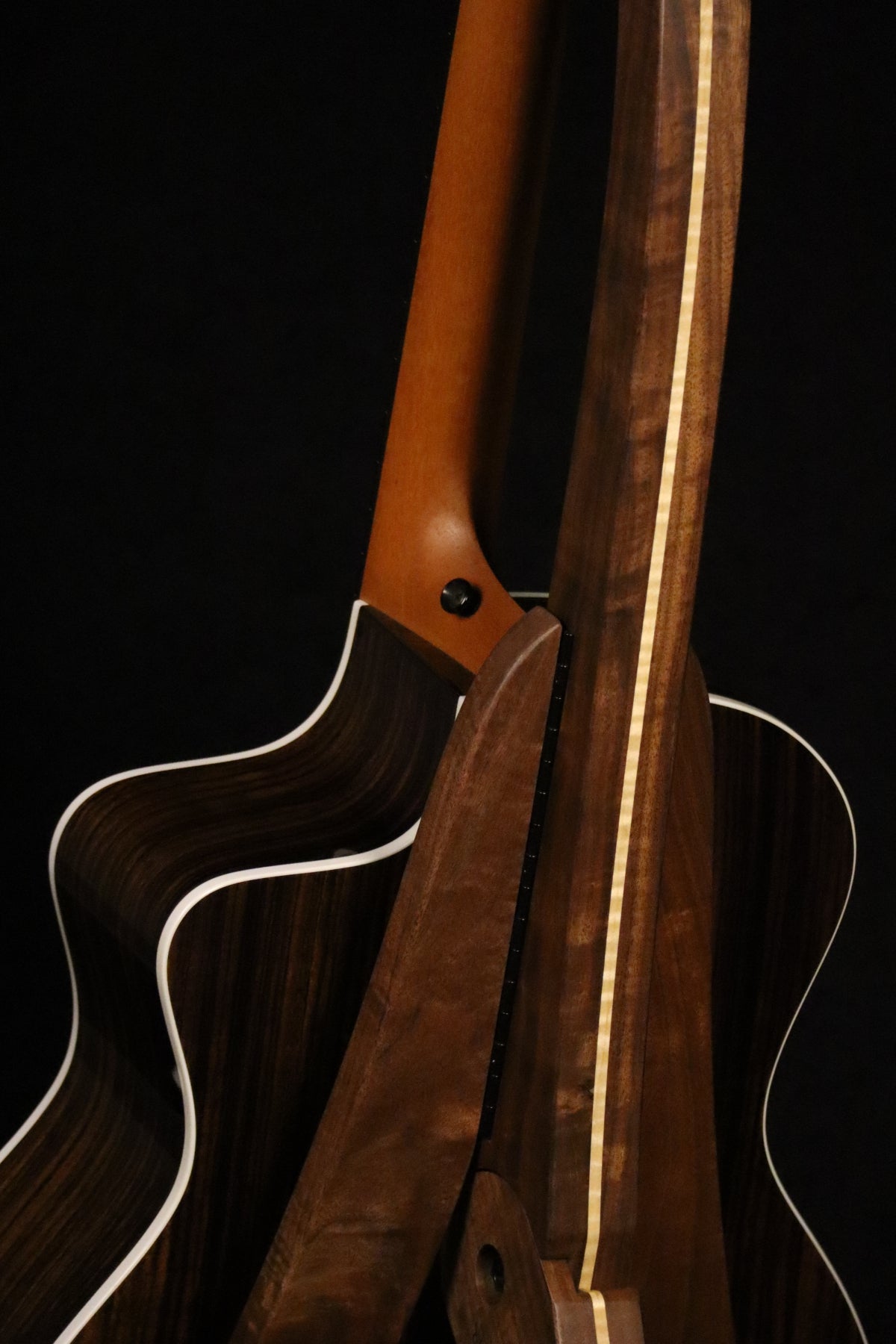 Folding walnut and curly maple wood guitar floor stand closeup rear image with Taylor guitar