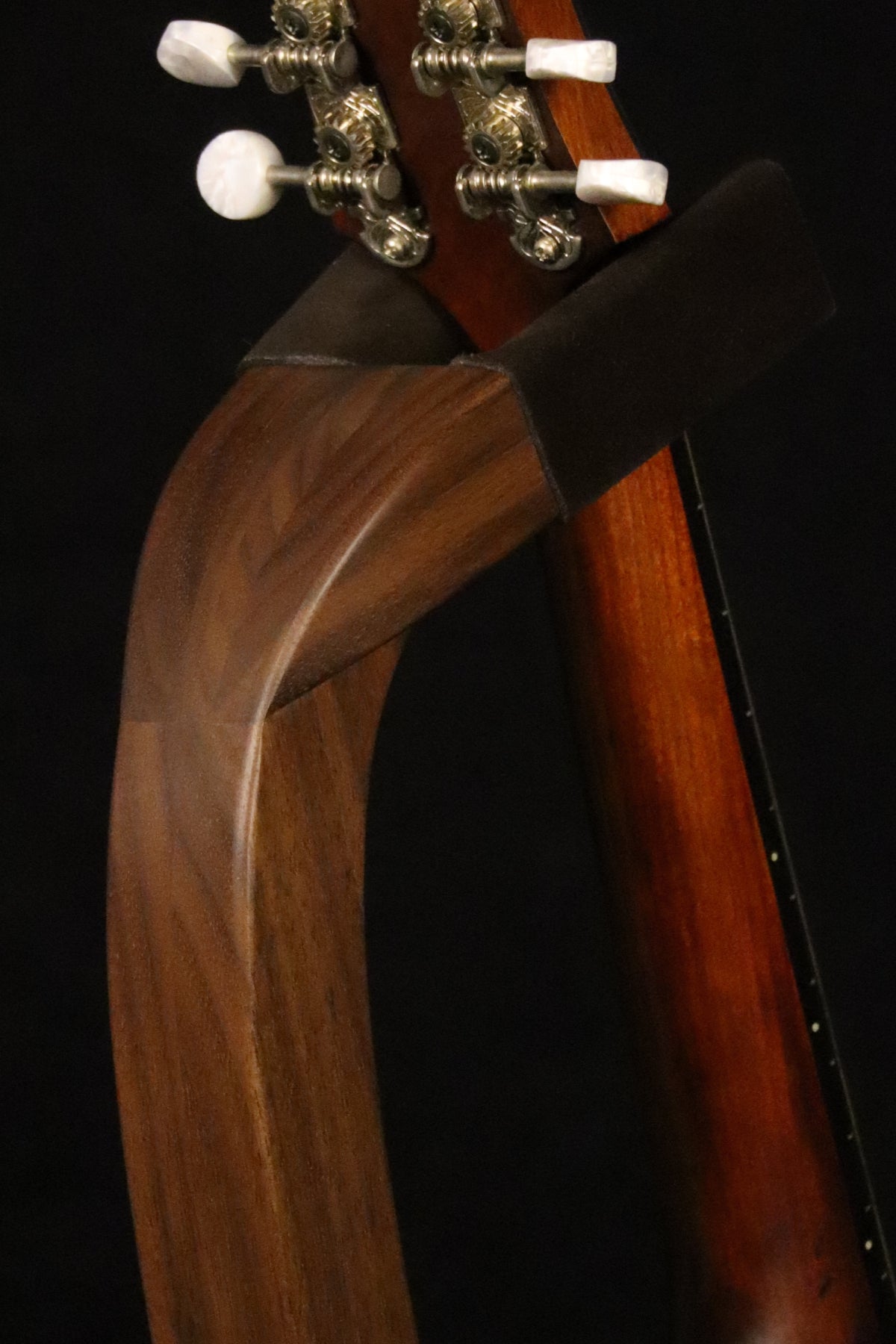 Folding walnut wood mandolin floor stand yoke detail image with Eastman mandolin