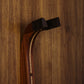 Sapele mahogany and curly maple wood guitar wall mount hanger installed on paneled wall