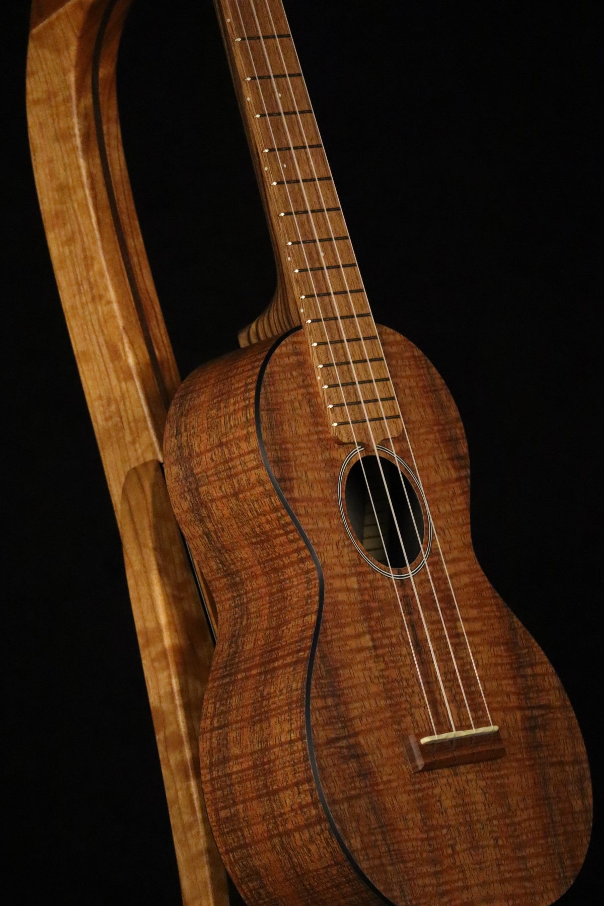 Folding cherry and walnut wood ukulele floor stand closeup front image with Martin ukulele