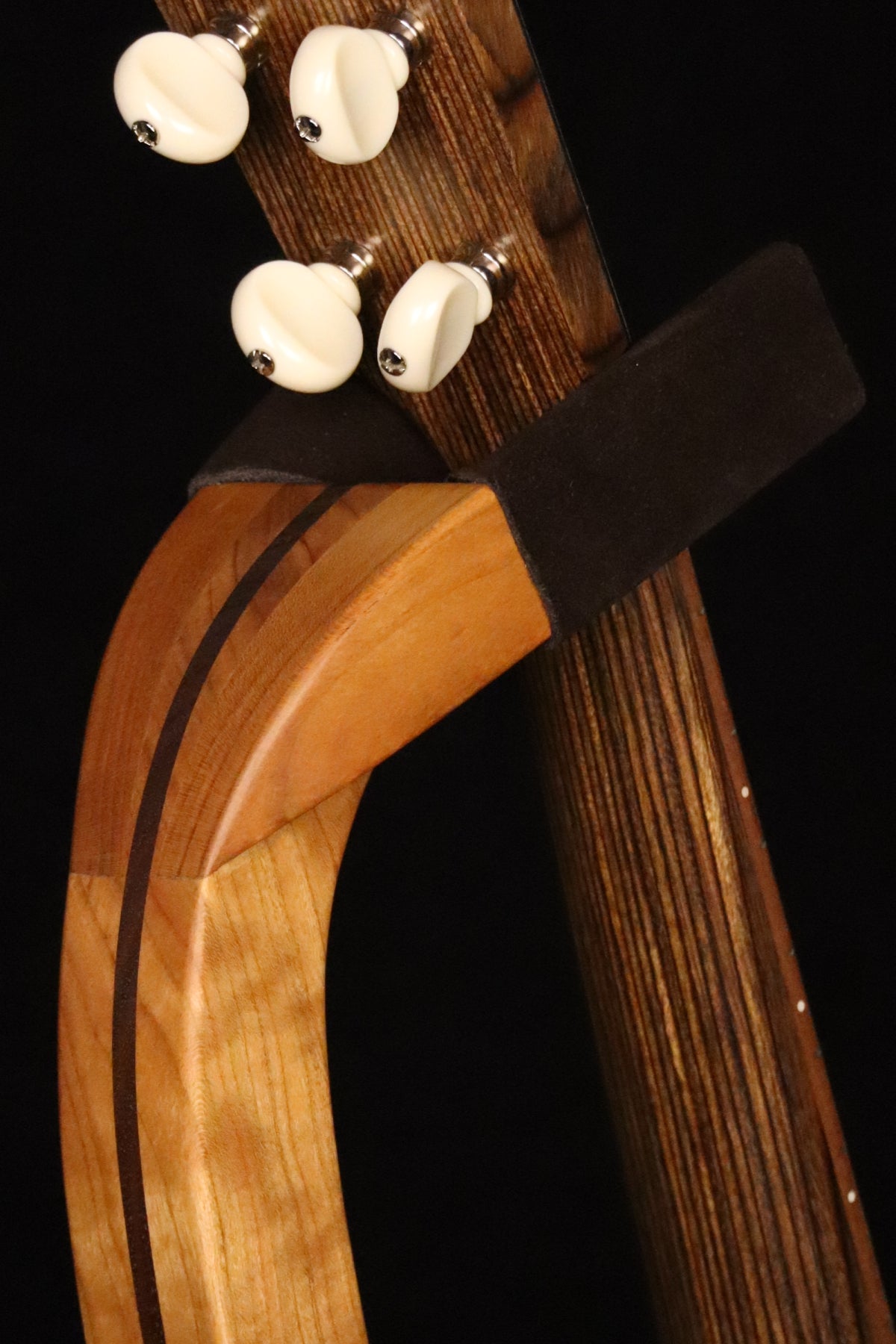 Folding cherry and walnut wood ukulele floor stand yoke detail image with Martin ukulele