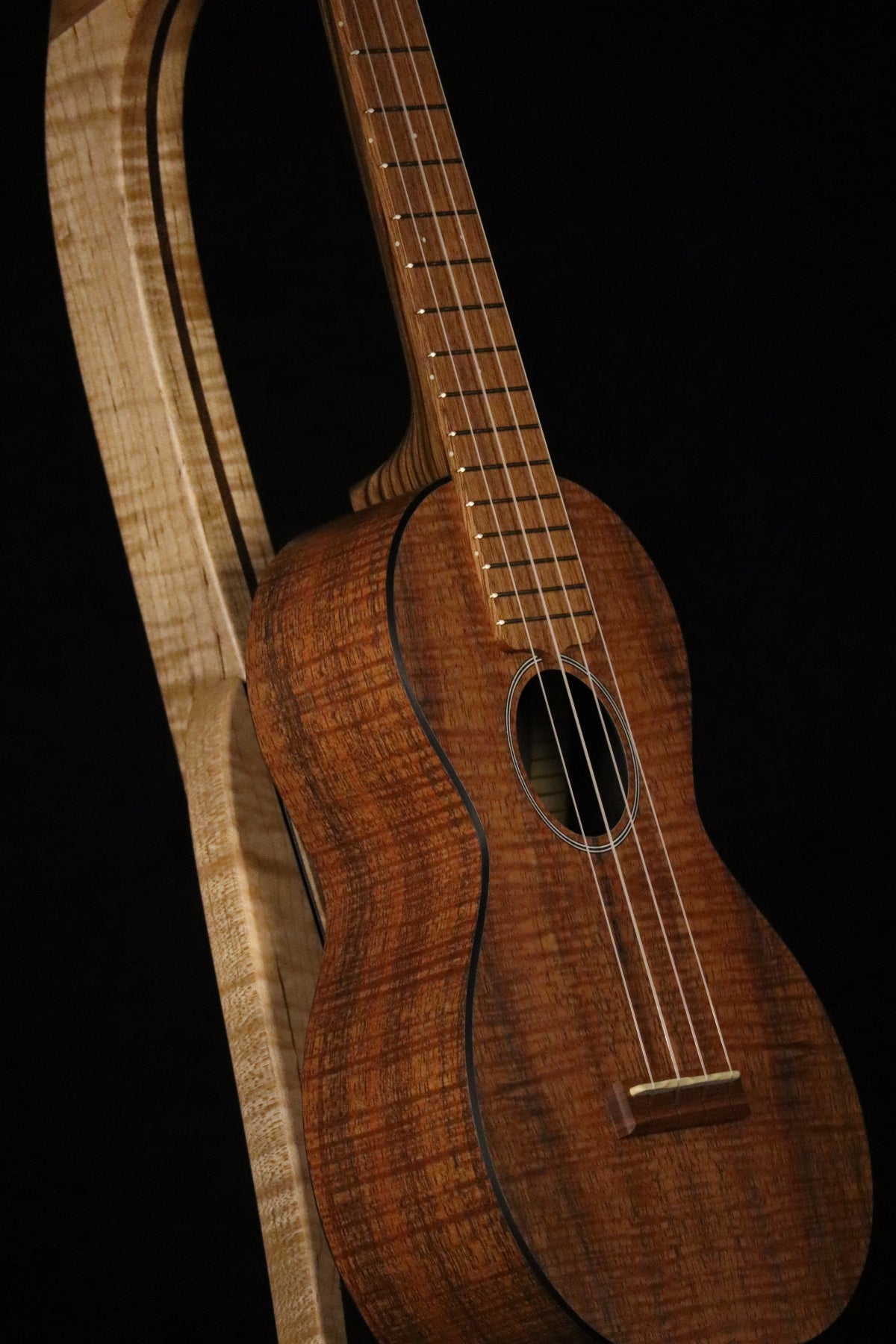 Folding curly maple and walnut wood ukulele floor stand closeup front image with Martin ukulele