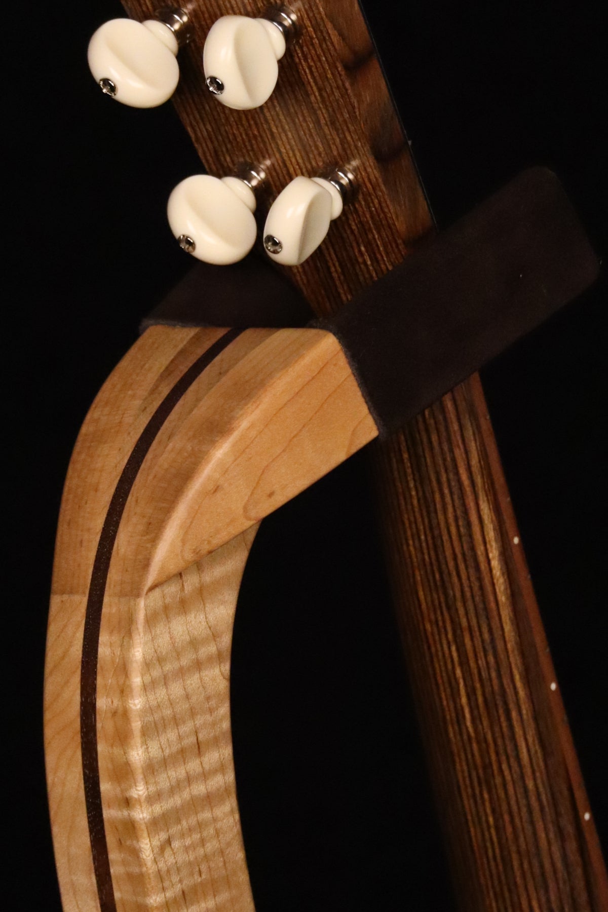 Folding curly maple and walnut wood ukulele floor stand yoke detail image with Martin ukulele